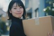 引っ越しで段ボールを持つ日本人女性（新生活・新居・進学・荷造り・荷物）