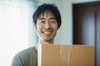 引っ越しで段ボールを持つ日本人男性（新生活・新居・進学・荷造り・荷物）