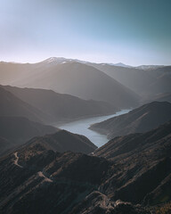 Wall Mural - the mountains are covered with hills and a river flowing through it