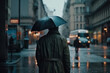 Back view of man holding an umbrella is walking in the rain in a big city.