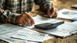 © Molang Visual - Accountant analyzing financial reports and using a calculator