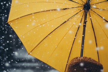 Poster - A person holding a yellow umbrella in the snow. Perfect for winter-themed designs and concepts