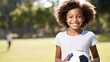 Teenager girl plays football. Football field and portrait with soccer ball. Teen Youth Soccer. Smiling girl holding soccer ball