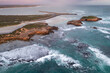 © Austockphoto - Aerial view of waves crashing against islands along a rugged coastline in bad weather