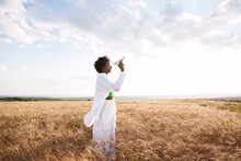 Woman Playing With Paper Plane Standing In Field