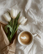 Elegant White Tulips and Coffee on Linen. Pristine white tulips wrapped in paper next to a cup of coffee on a linen backdrop.
