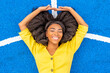 © VISTA by Westend61 - Happy young woman with eyes closed lying on blue basketball court