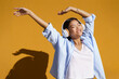 © VISTA by Westend61 - Young woman with headphones listening to music enjoying in front of wall