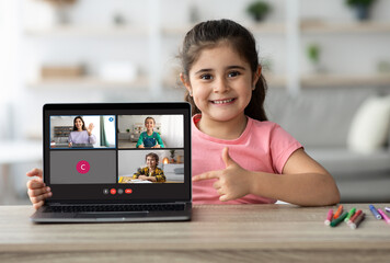 Poster - Sweet little girl studying from home, pointing at laptop