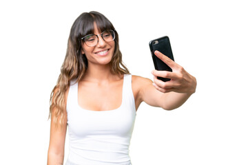 Wall Mural - Young caucasian woman over isolated background making a selfie with mobile phone
