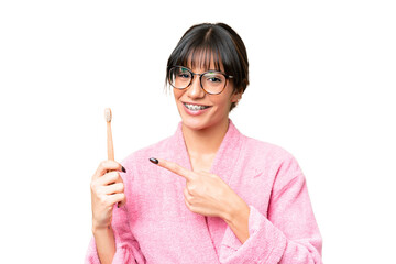 Wall Mural - Young caucasian woman holding a toothbrush over isolated chroma key background and pointing it