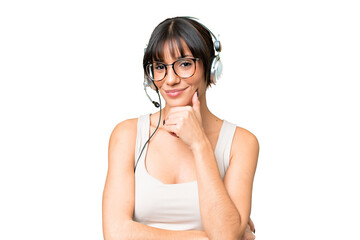 Wall Mural - Telemarketer caucasian woman working with a headset over isolated background smiling