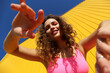 © VISTA by Westend61 - Smiling woman gesturing near yellow wall at sunny day