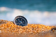 © yanik88 - compass on sea sand and place for text. close up of navigation device on sandy beach without people, top view