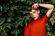 © VISTA by Westend61 - Contemplating gender fluid man standing against leaves in park