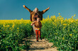 © VISTA by Westend61 - Playful mother and son running in rapeseed field
