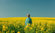 © VISTA by Westend61 - Woman standing amidst flowers in rapeseed field