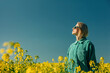 © VISTA by Westend61 - Woman standing amidst flowers in rapeseed field at sunny day