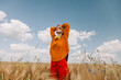 © VISTA by Westend61 - Woman with head in hands standing in wheat field
