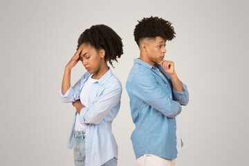 Wall Mural - Upset young African American woman and man standing back to back