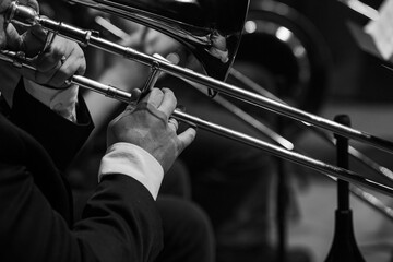 Poster -  A fragment of a trombone in the hands of a musician close-up in black and white