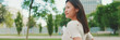 © Andrii Nekrasov - Beautiful brunette girl is resting sitting on bench in city park, Panorama