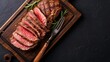 © Sasint - Sliced grilled roast beef with fork for meat on wooden cutting board. Black background. Top view.