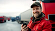 © PETR BABKIN - Happy truck driver talking on his cell phone and looking at the camera.