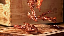Roasted Slices Of Bacon Fall On A Wooden Table. Filmed On A High-speed Camera At 1000 Fps. High Quality FullHD Footage