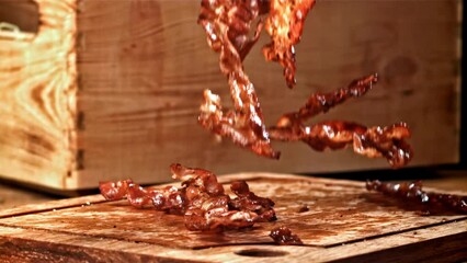 Poster - Roasted slices of bacon fall on a wooden table. Filmed on a high-speed camera at 1000 fps. High quality FullHD footage