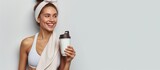Fototapeta  - Portrait happy young woman in sportswear, white towel, holding healthy drink after gym. AI generated