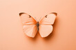 Gentle peach fuzz butterfly resting on flowers on minimal background. Modern trendy tone hue shade