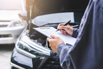 Auto check, car service shop concept. Automobile repairman writing job checklist on clipboard, mechanic checking engine to estimate repair machine, inspecting maintenance by engineer at vehicle garage