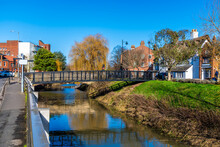 A View Towards A Footbridge Over The River Welland Opposite Welland Place In The Centre Of Spalding, Lincolnshire On A Bright Sunny Day