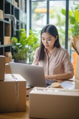 Poster - A woman sitting at a table working on a laptop. Suitable for business and remote work concepts
