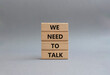 We need to talk symbol. Concept words We need to talk on wooden blocks. Beautiful grey background. Business and We need to talk concept. Copy space.