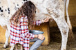 © ADDICTIVE STOCK - Farmer woman milking a dairy cow on a rural farm