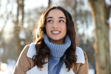 Wall Mural - Portrait of smiling woman in winter snowy park