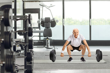 Canvas Print - Senior man lifting a barbell