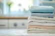 Clean bedding sheets stacked on a blurry laundry room backdrop
