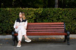 © Вячеслав Думчев - Young lonely woman sitting on a park bench and waiting for someone