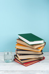Canvas Print - Book stacking. Open book, hardback books on wooden table and green background. Back to school. Copy space for text.