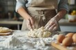 Close up of woman kneading dough for homemade cookies at kitchen table