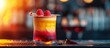Beautiful colorful cocktail with raspberry and balsamic on a plastic stick, blurry bar background.