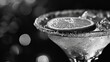  a black and white photo of a martini glass with a slice of lemon on the rim of the glass and bubbles on the rim of the rim of the glass.