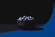 © ADDICTIVE STOCK - A minimalist composition featuring a black bowl of blueberries on a split blue and black background with dramatic lighting