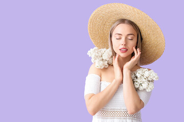 Wall Mural - Young woman with lilac flowers on color background