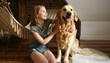 © Ievgen Skrypko - Girl child with golden retriever dog sitting at floor together at home with hammock. Pretty preteen kid hugging purebred doggy pet in loft room