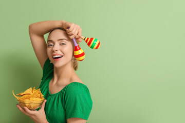 Canvas Print - Pretty young woman with nachos and maracas on green background