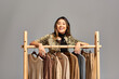 © LIGHTFIELD STUDIOS - joyful asian stylist looking at camera near rack with trendy clothes on grey, small business